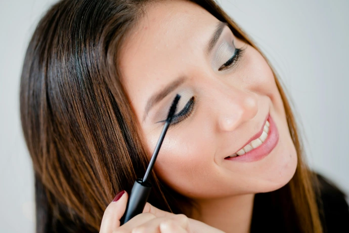 woman holding black pen smiling Organic Beauty Salon